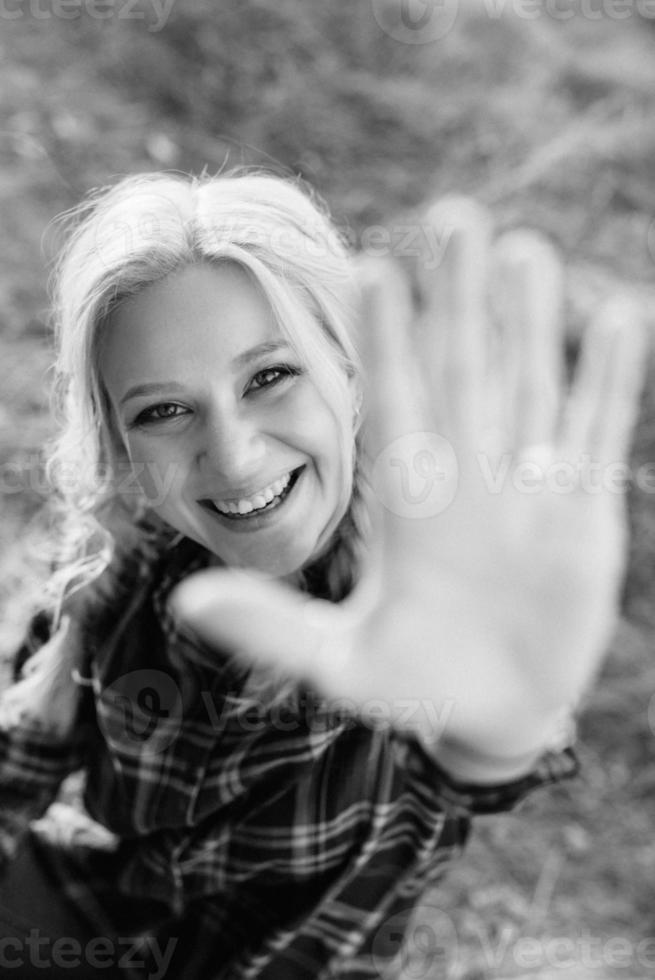 loira com tranças em uma camisa jeans sapatos vermelhos sorrindo foto