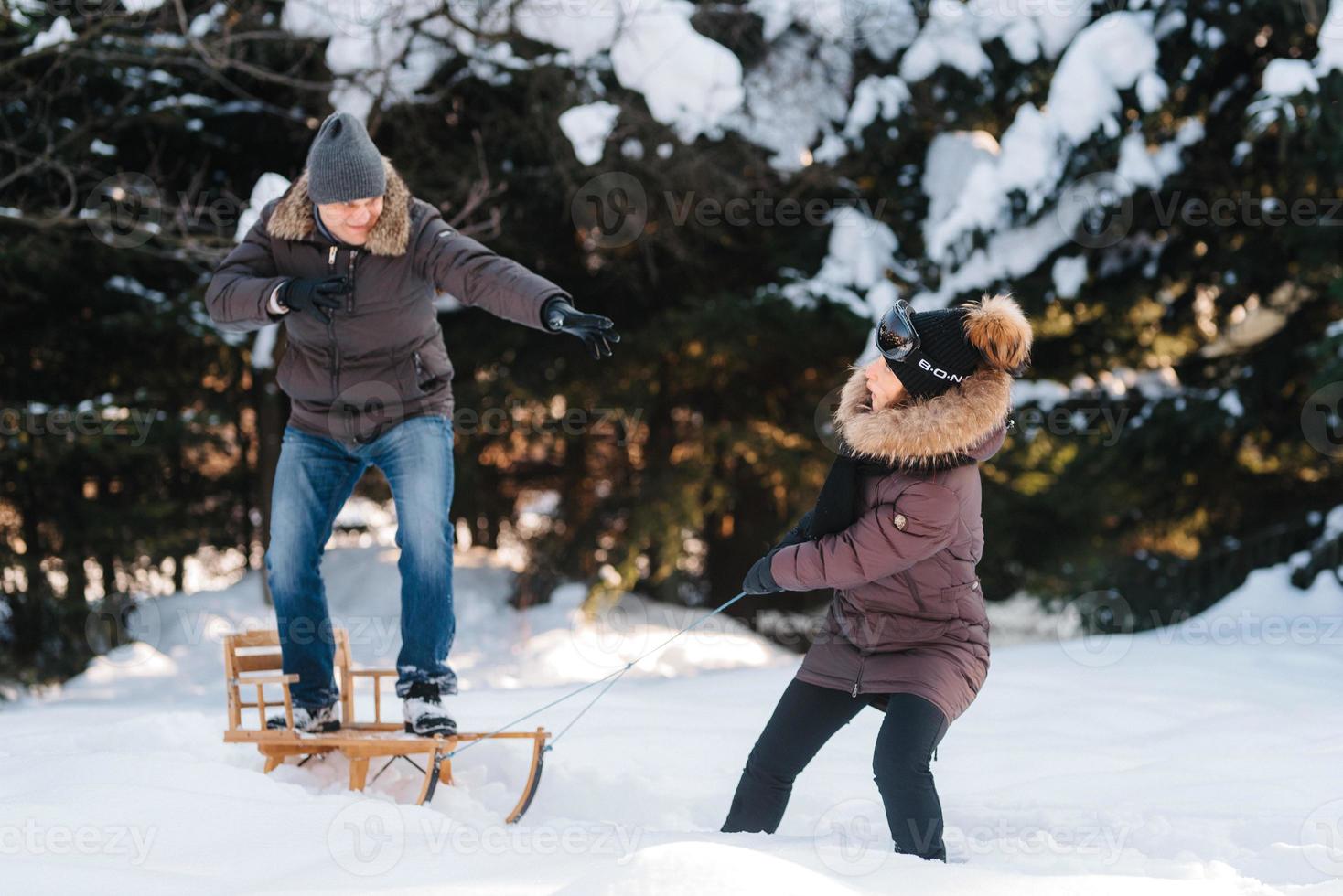 menino e menina ao ar livre em uma caminhada de inverno jogando bolas de neve foto