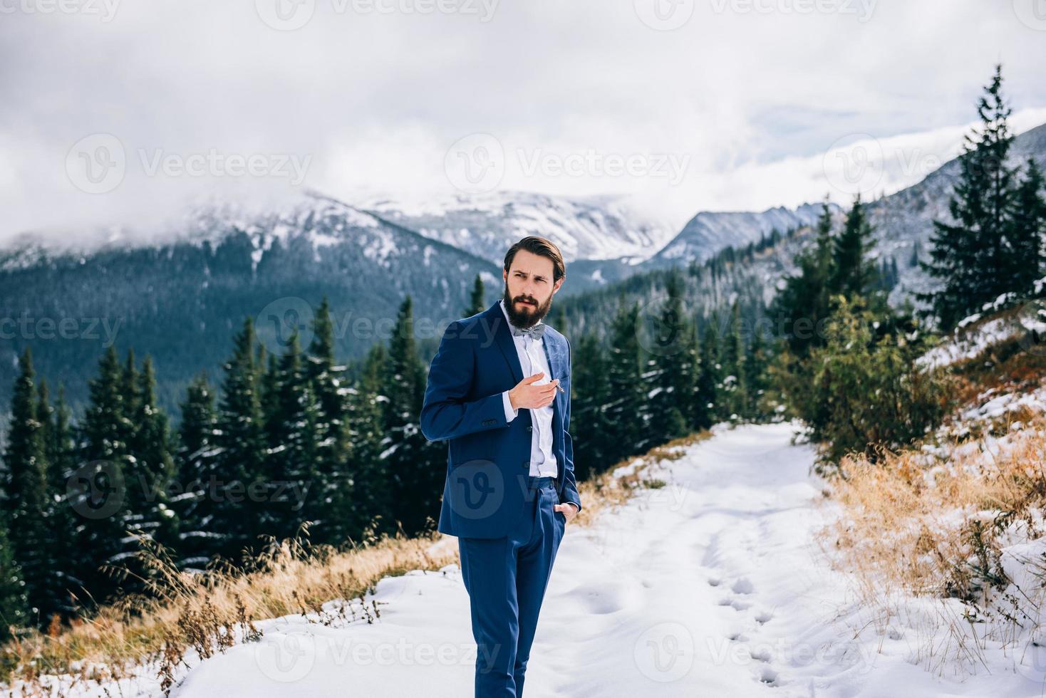 noivo em um terno azul nas montanhas dos Cárpatos foto
