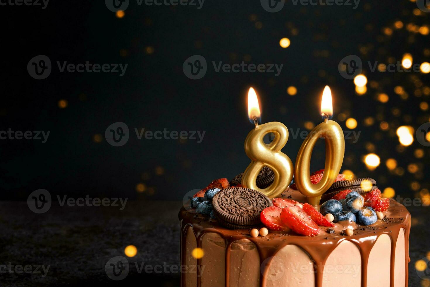 chocolate aniversário bolo com bagas, biscoitos e número oitenta dourado velas em Preto fundo, cópia de espaço foto