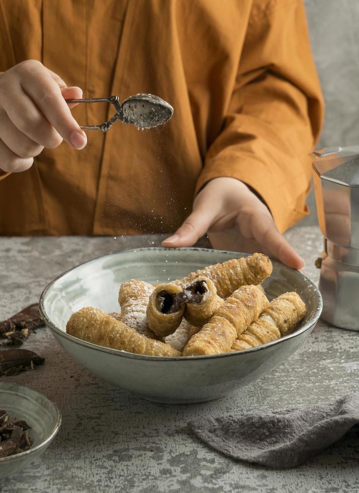 pessoa comendo um delicioso prato de tequenos foto