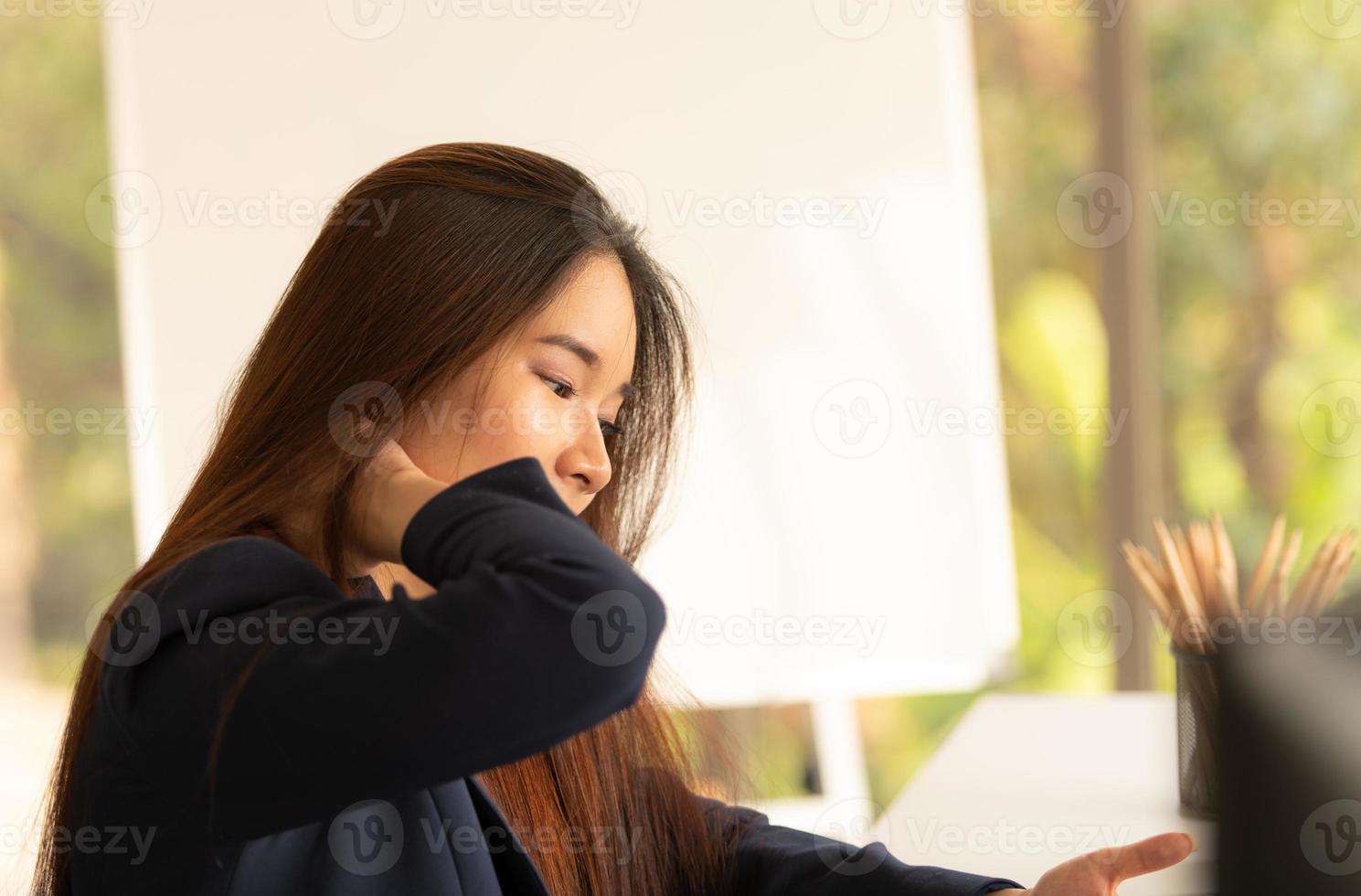 mulher de negócios asiáticos segurando a dor de garganta de trabalhar e usar o computador. síndrome de escritório foto