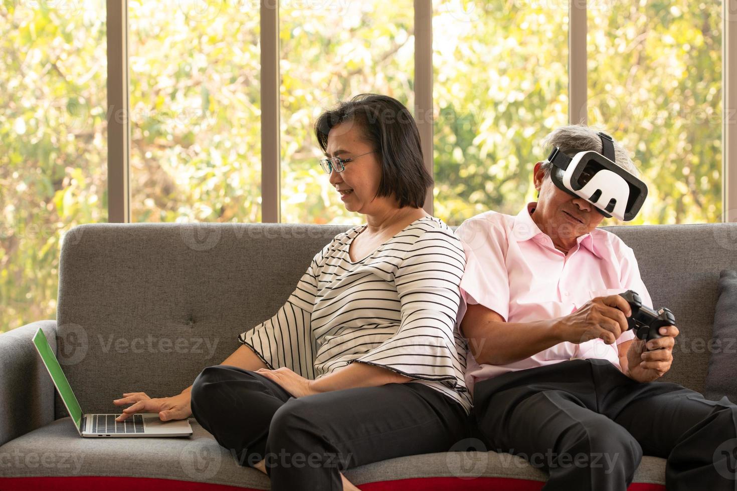 mulher e homem asiático sênior relaxam nas férias no fundo natural da sala de estar com tecnologia moderna foto