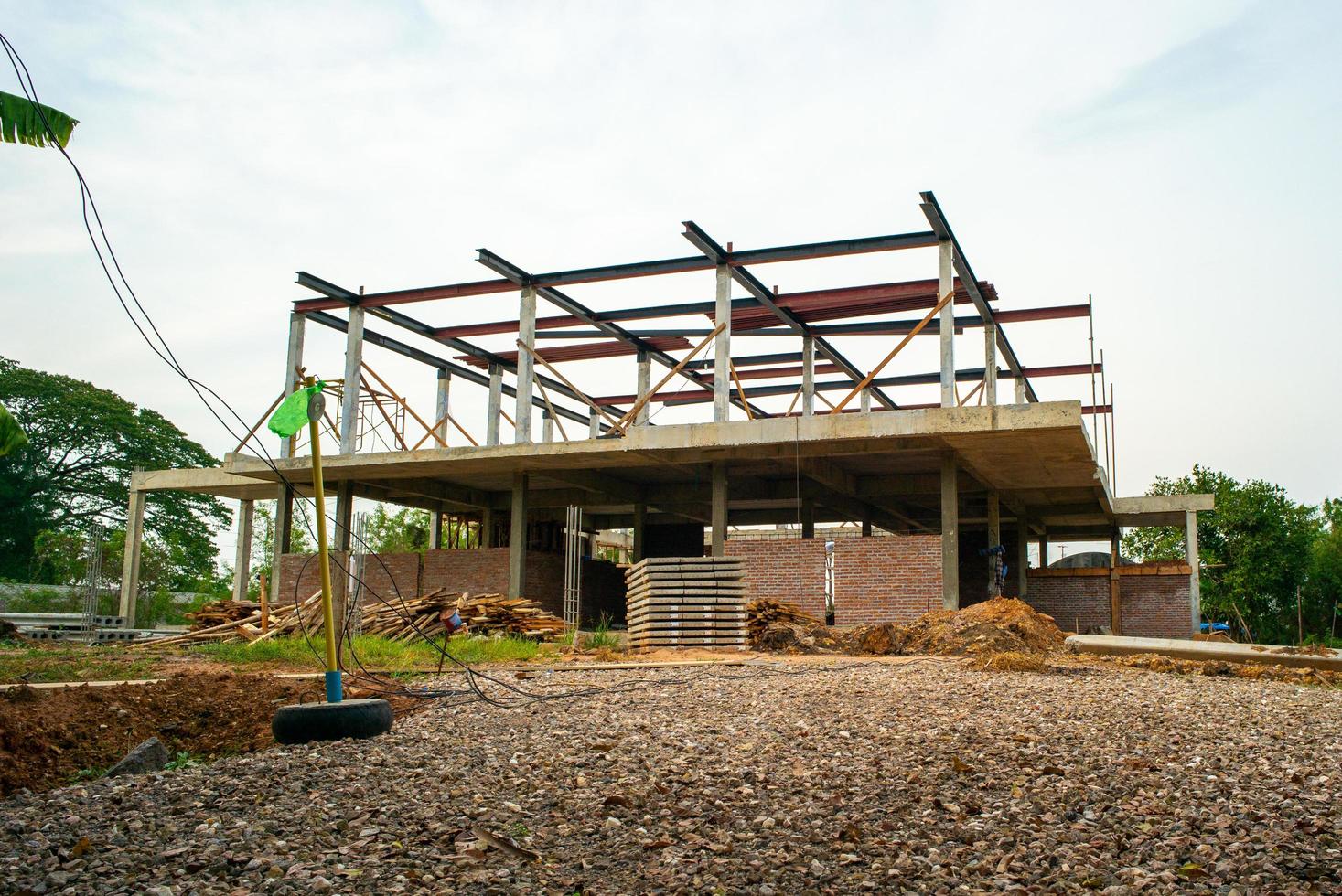 uma estrutura de casa em construção em um local com fundo de céu azul foto