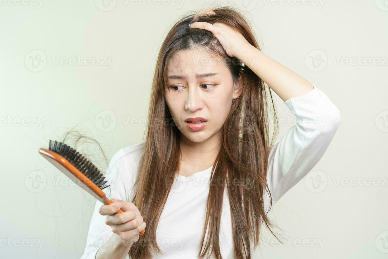 sério, preocupado ásia jovem mulher, menina segurando escovar, mostrar dela pentear, escova de cabelo com grandes perda cabelo problema depois de escovar, cabelo outono Fora em dela mão dentro vivo sala. saúde Cuidado, beleza tratamento. foto