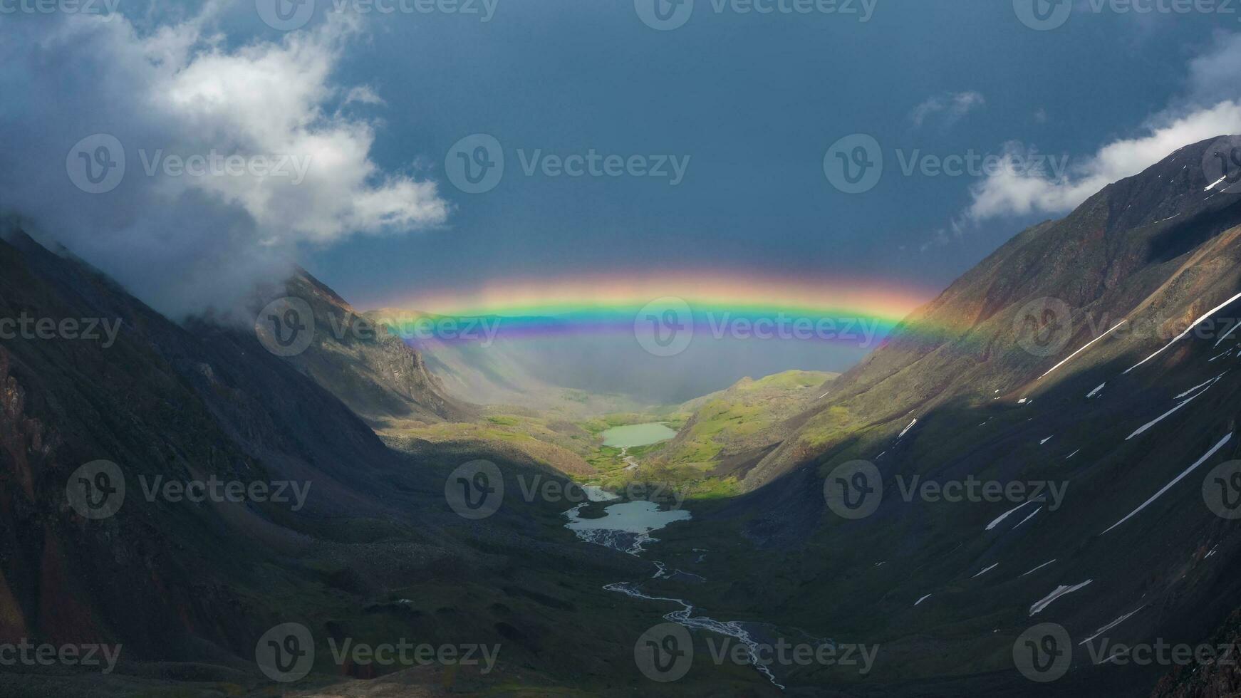 cheio arco Iris sobre uma montanha vale. atmosférico alpino panorama com Nevado montanhas com arco Iris dentro chuvoso e ensolarado clima. foto