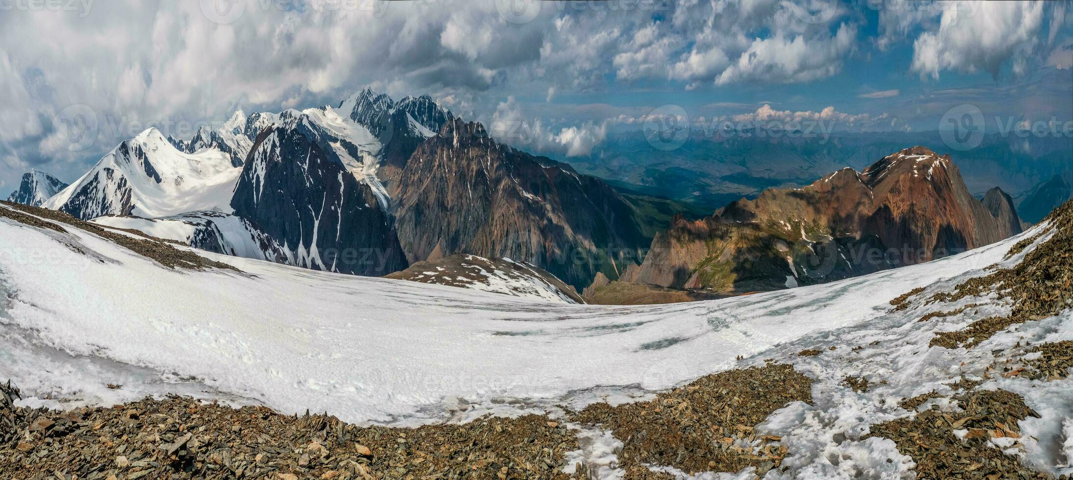 Nevado grande altitude platô. panorâmico alpino panorama com coberto de neve montanha pico debaixo dramático azul céu. colorida ensolarado montanha cenário com neve montanha topo. foto