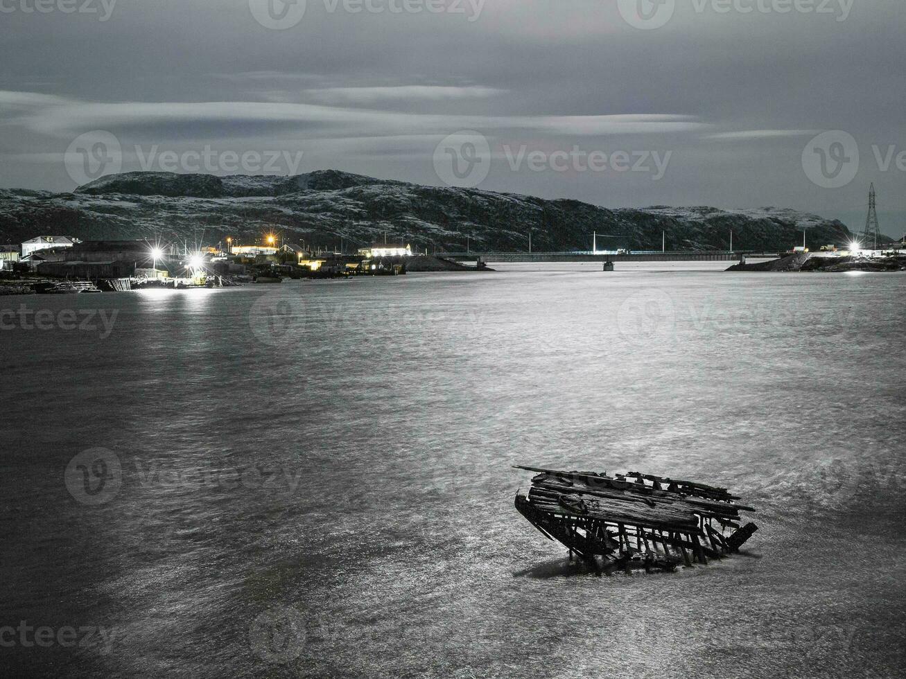 noite Visão do cemitério do navios, velho pescaria Vila em a costa do a barents mar, a cola Península, teriberka foto