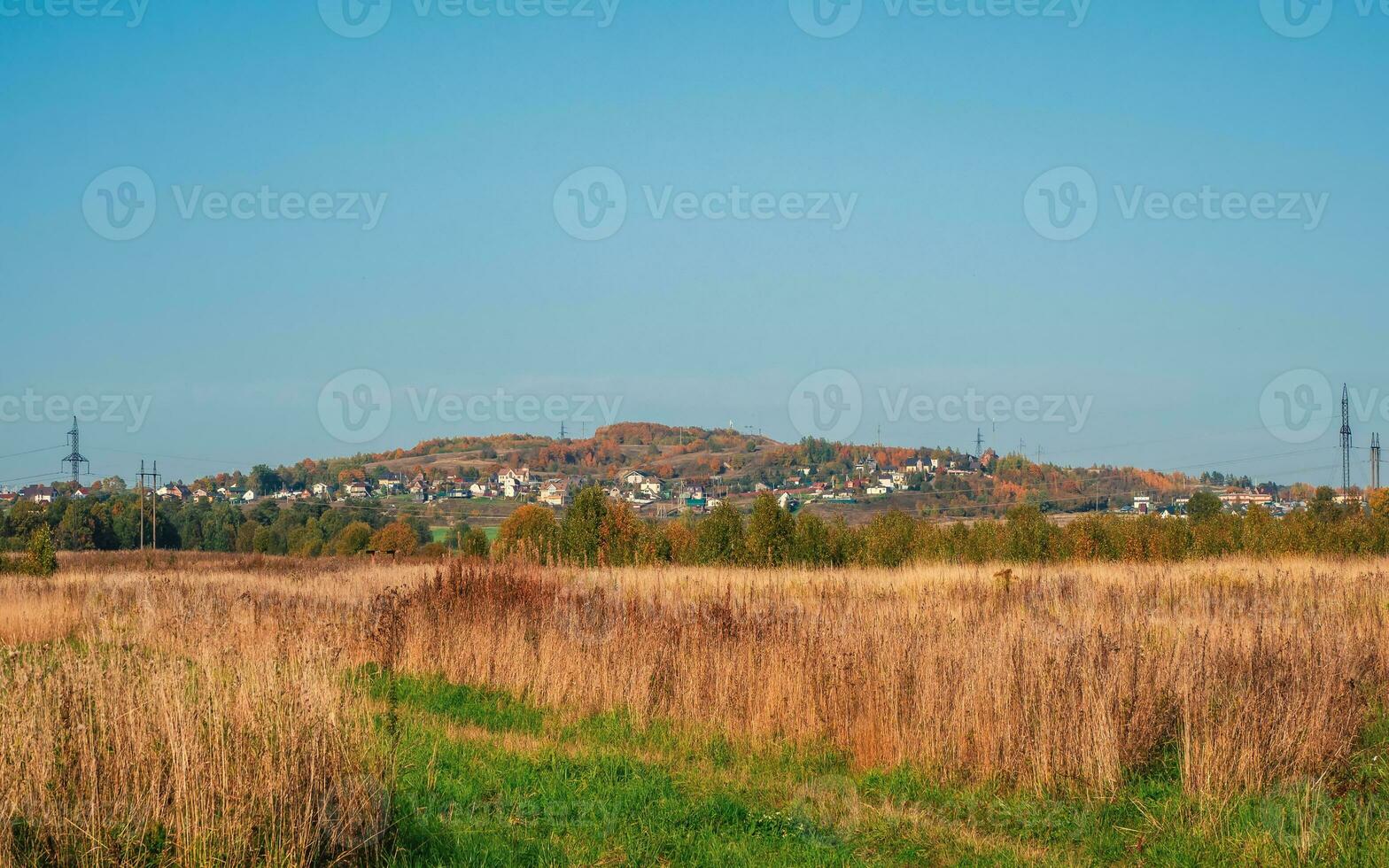 país vida. uma Vila em uma colina. Vila em a horizonte através a outono campo. foto