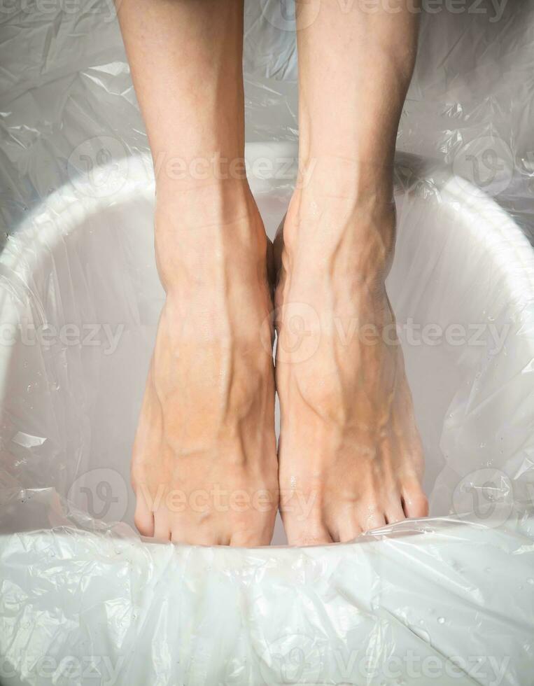 cansado pés, mulheres pés dentro uma relaxante banho. foto
