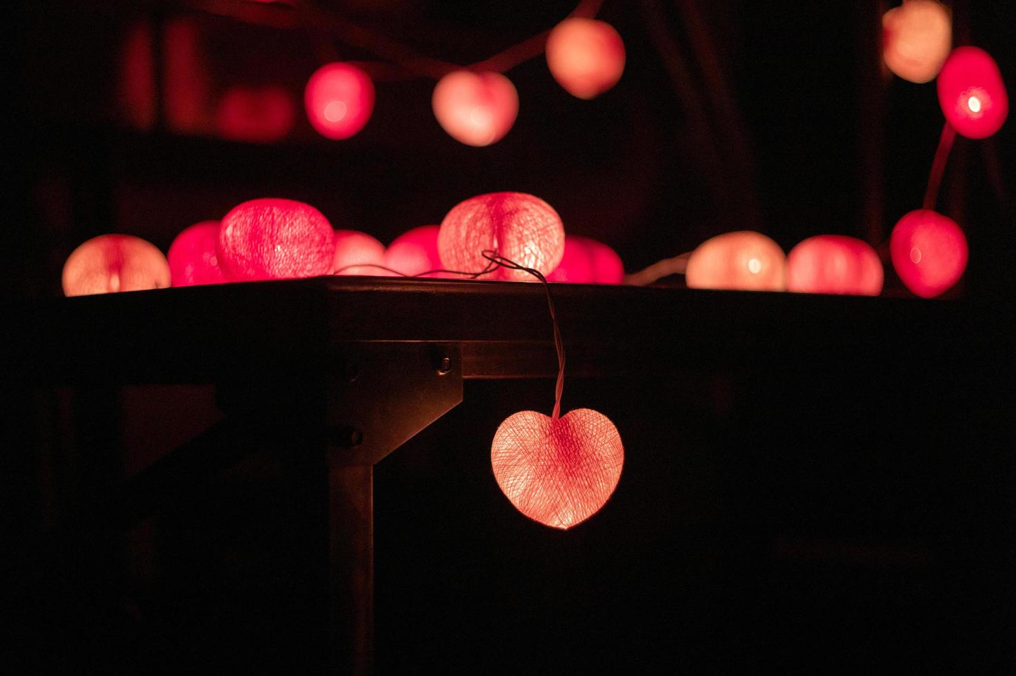 close de luzes led em forma de coração decoradas na câmara escura foto