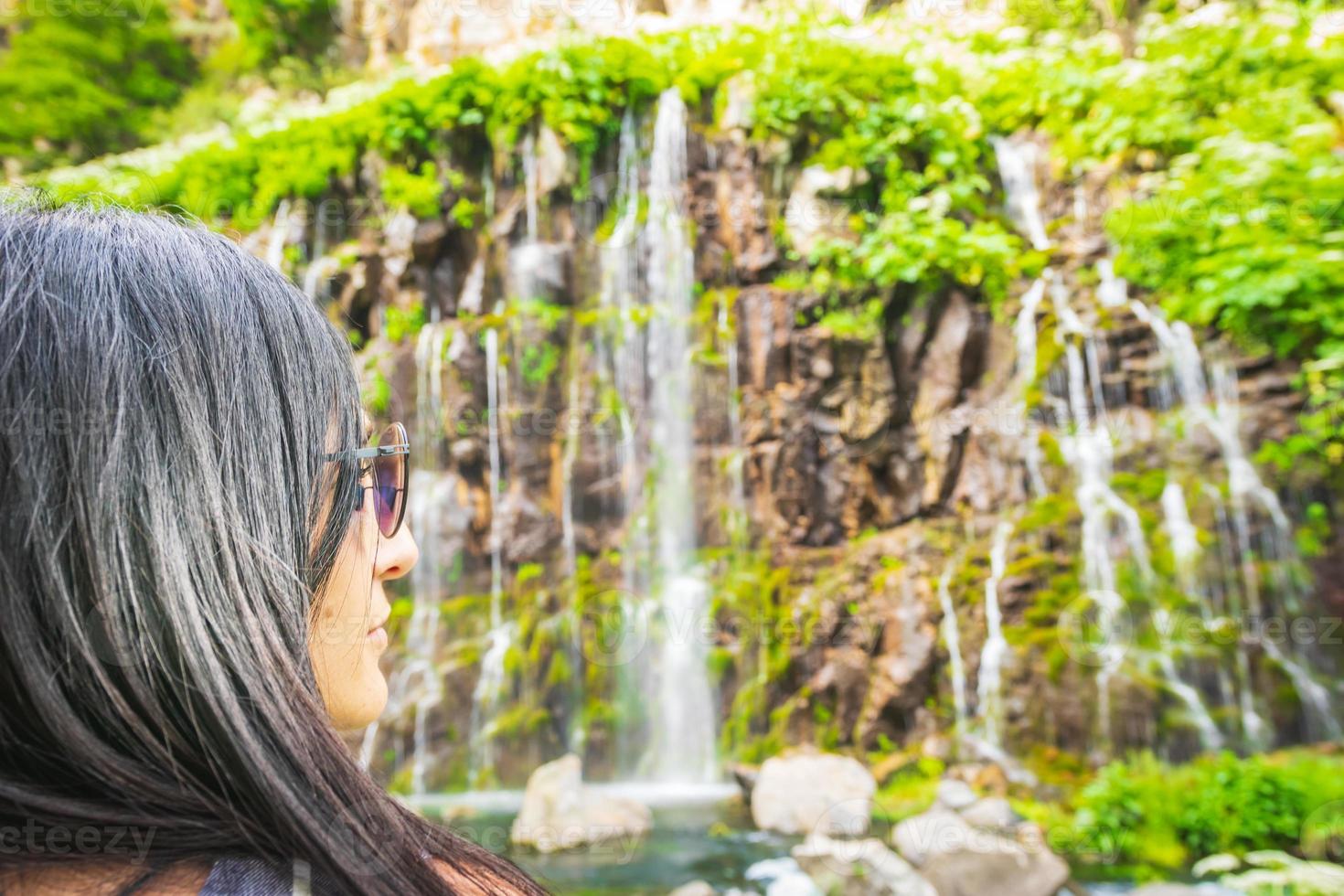 mulher olhando para uma cachoeira foto