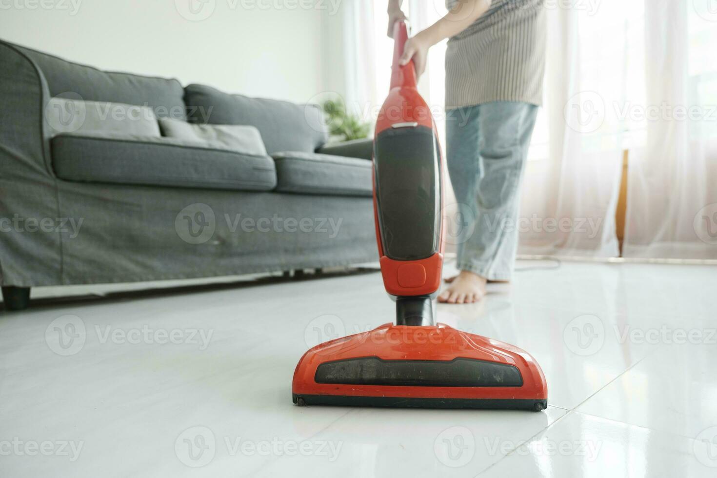 jovem mulher limpeza casa com vácuo limpador. foto
