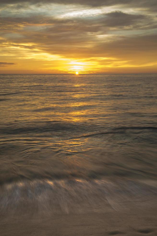 pôr do sol com ondas de motion blur na praia de punta lobos, santos baja california sur mexico foto