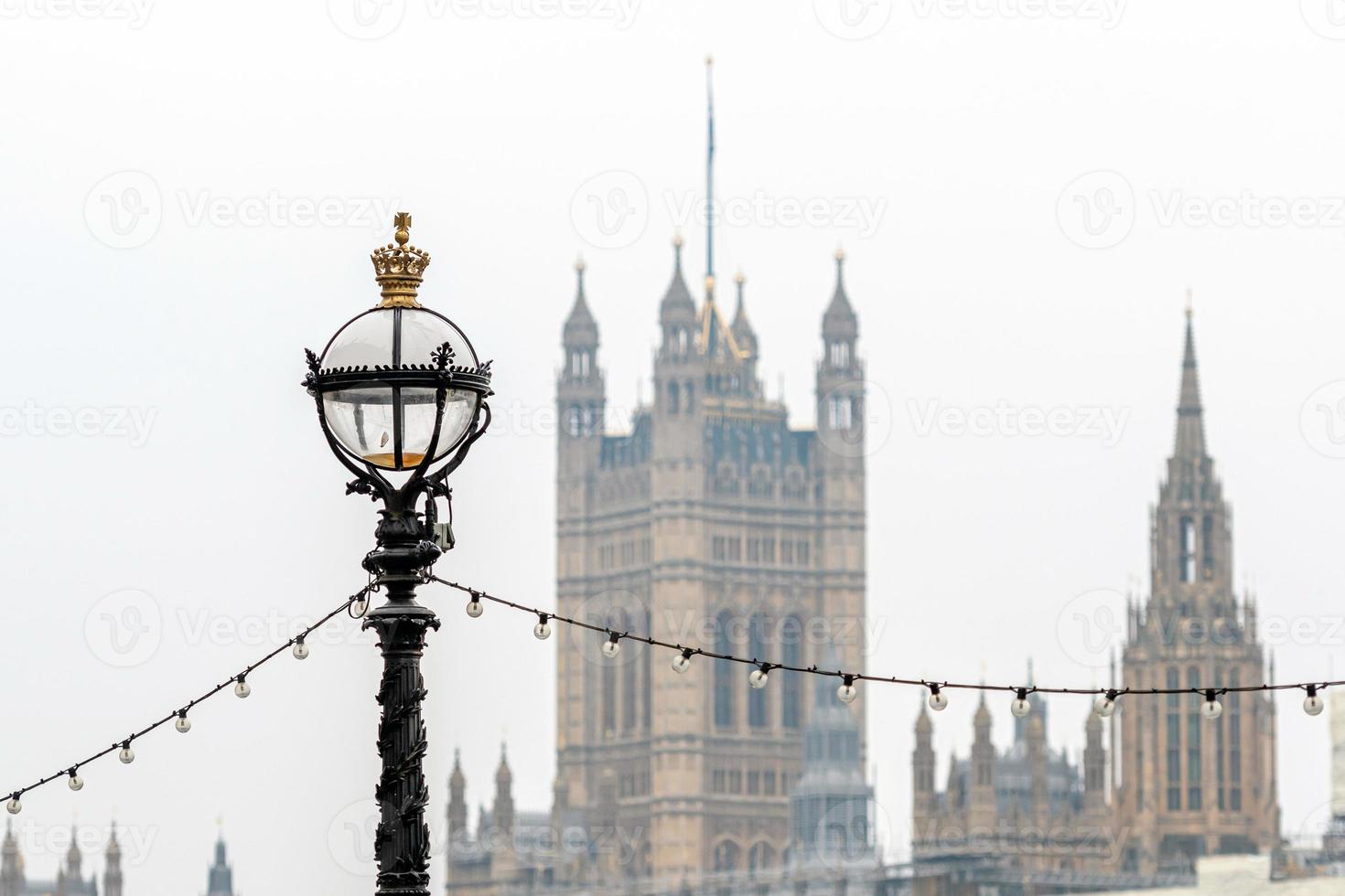 padrão de lâmpada de golfinho no dique de Tamisa em Londres, na ponte de Westminster, abadia de Westminster inchada no fundo foto