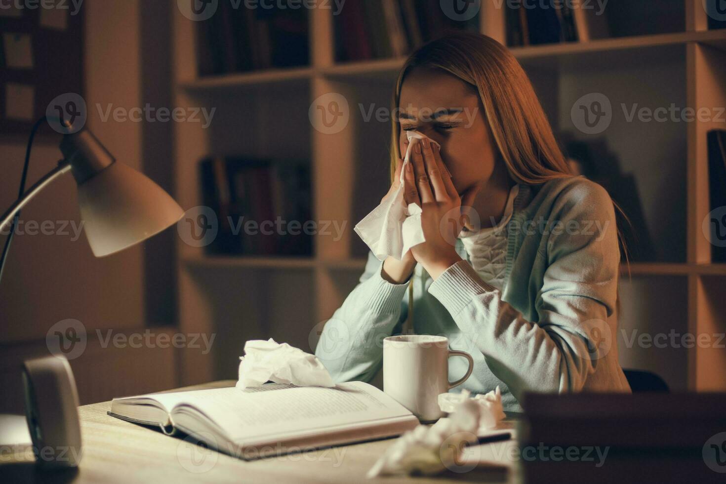 cansado Faculdade menina estudando atrasado noite às casa com a gripe foto