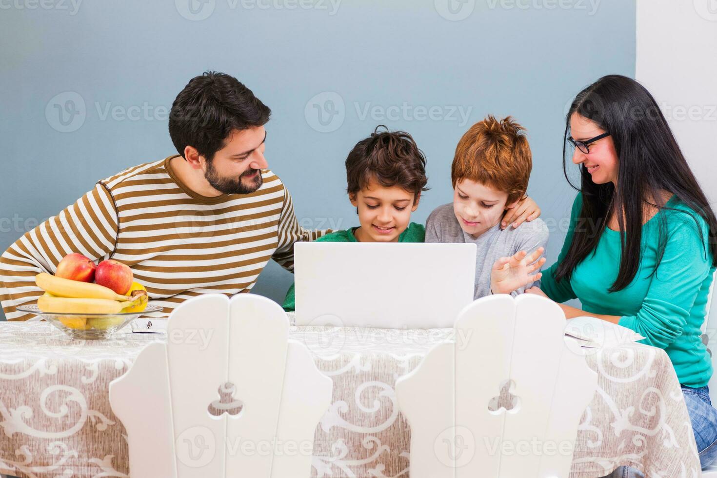 pais estão ensino seus crianças para usar a computador portátil foto