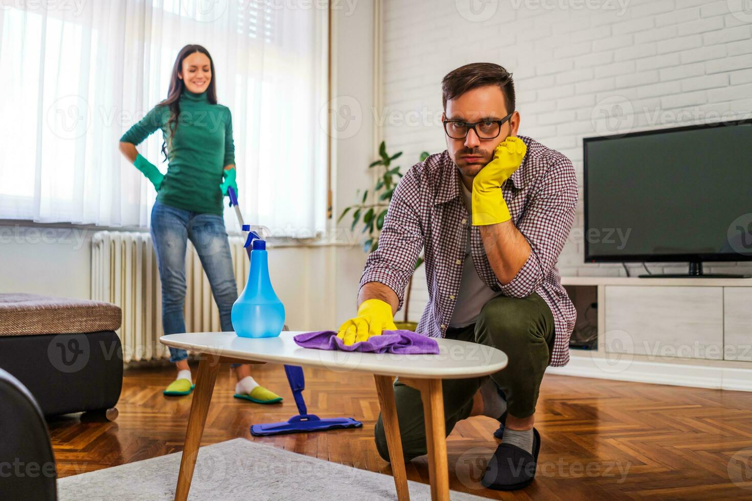 jovem casal é Exausta a partir de limpeza seus apartamento foto