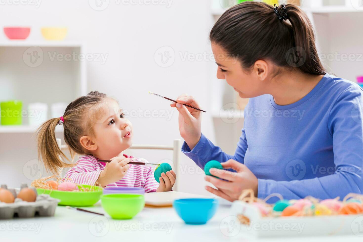 uma mãe e filha pintura ovos foto