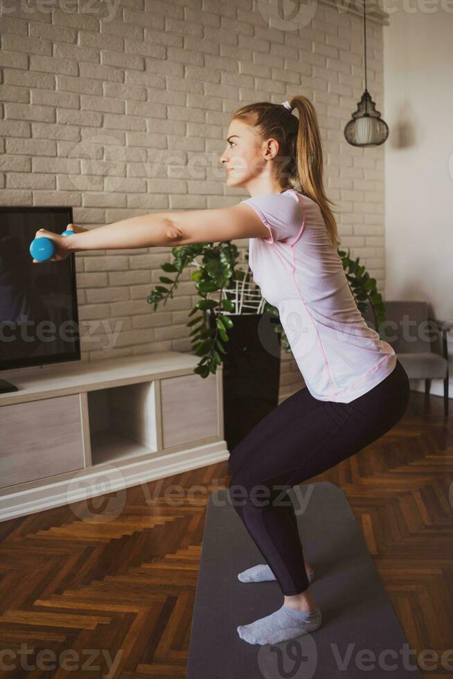 jovem mulher fazendo fisica exercícios às casa foto