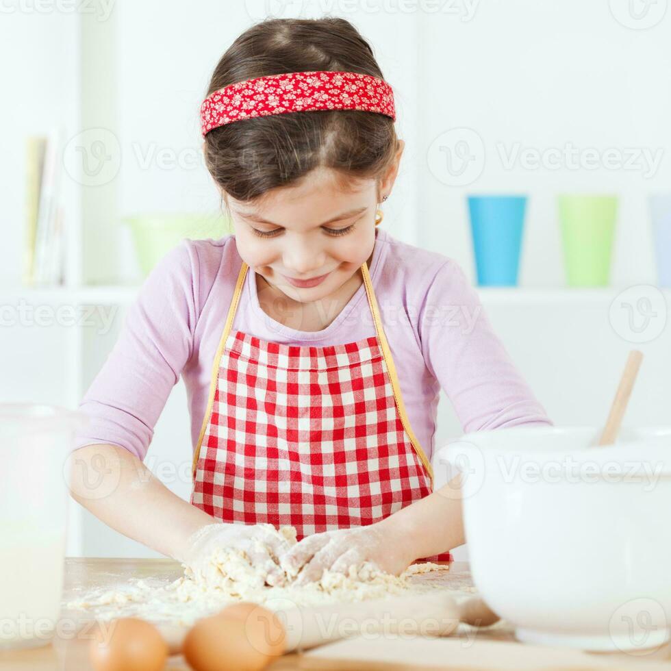 uma jovem menina cozinhando foto