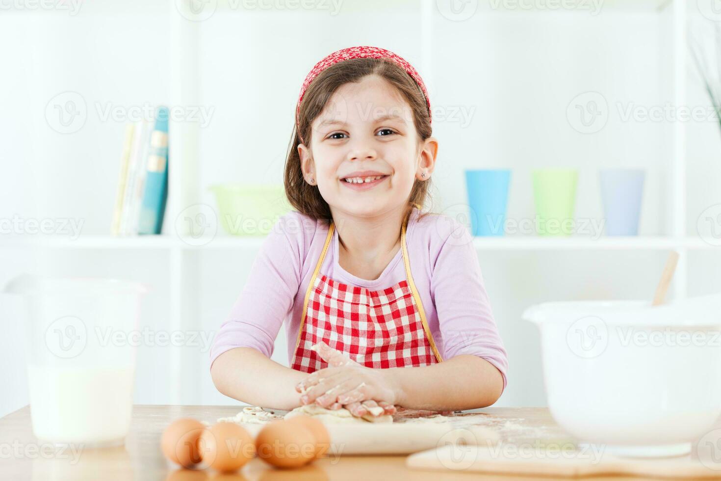 uma jovem menina cozinhando foto