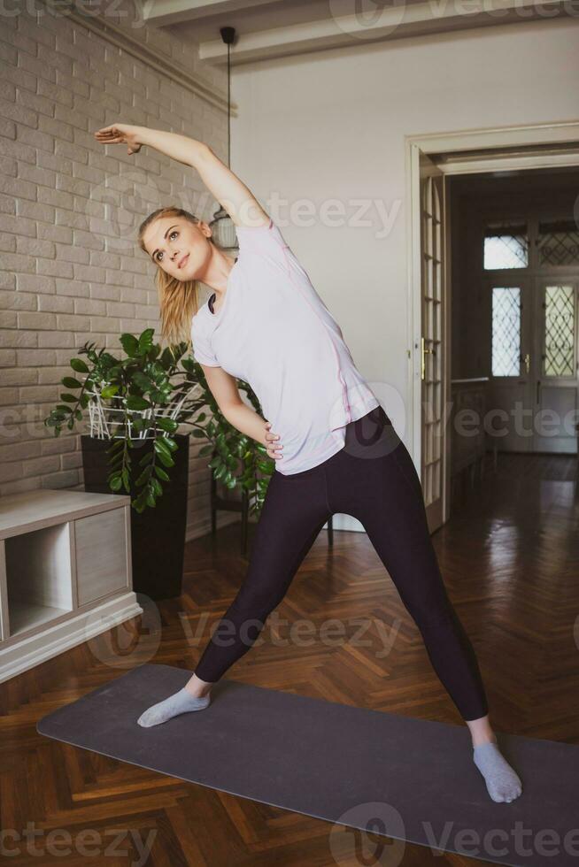 jovem mulher fazendo fisica exercícios às casa foto