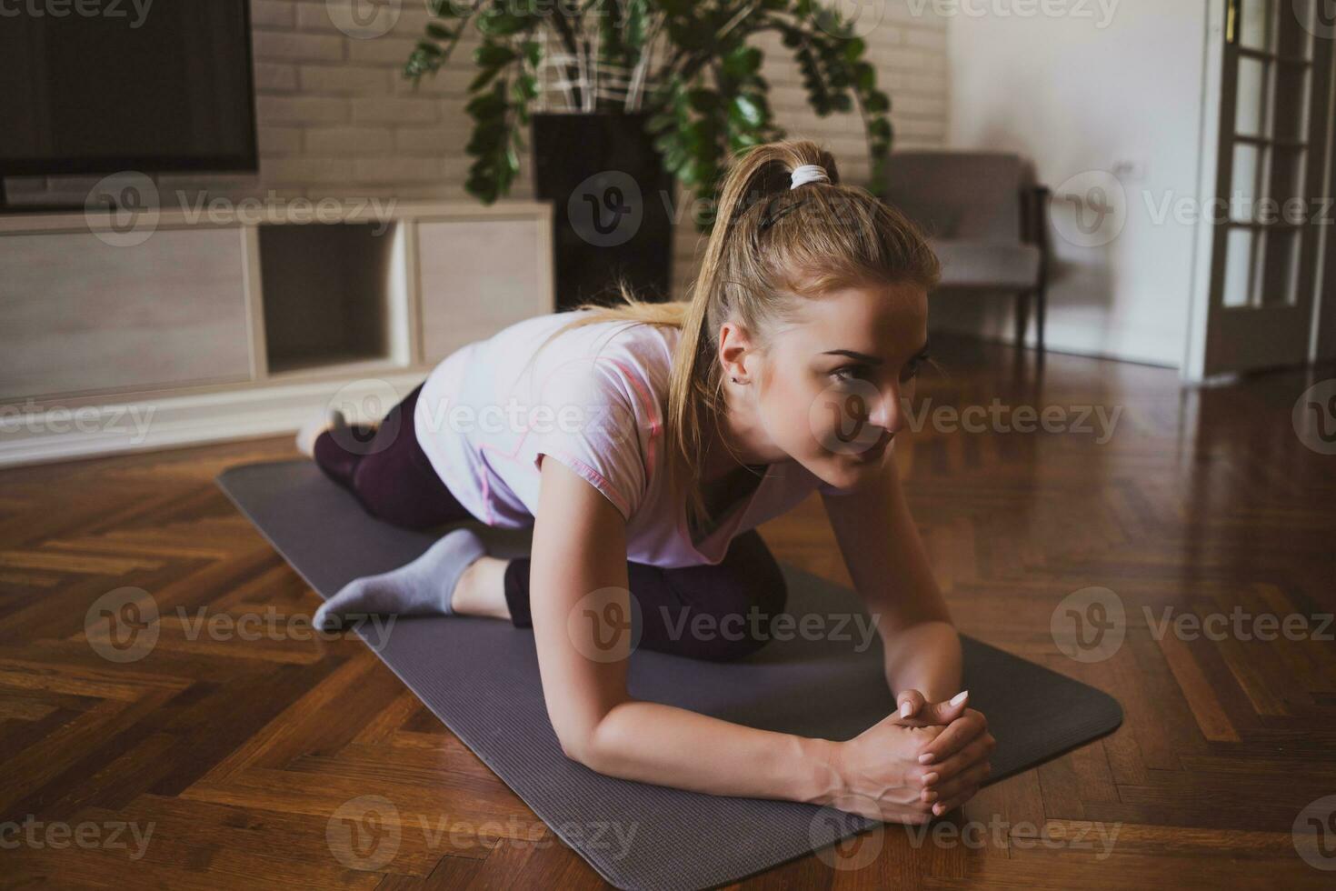 jovem mulher praticando pilates e ioga exercícios às casa foto