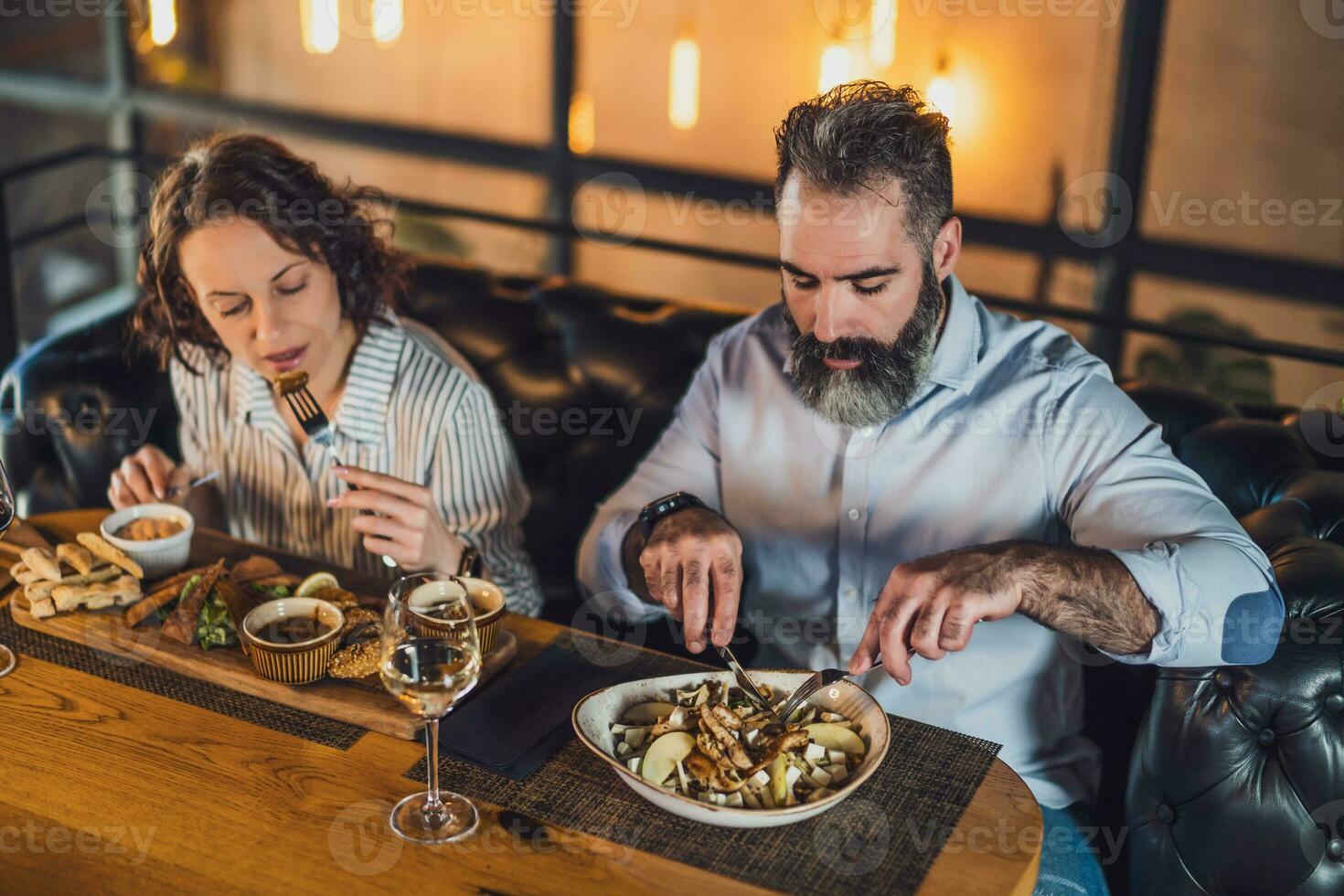 uma casal tendo jantar foto