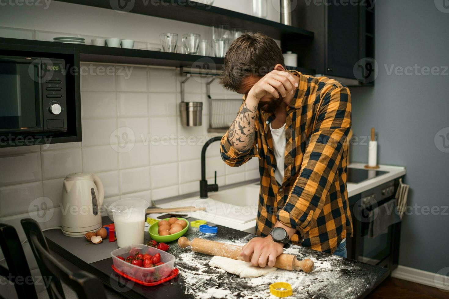 uma homem cozimento biscoitos dentro a cozinha foto