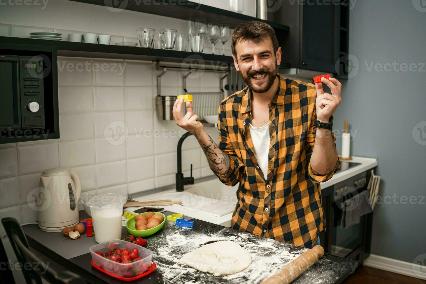 uma homem cozimento biscoitos dentro a cozinha foto