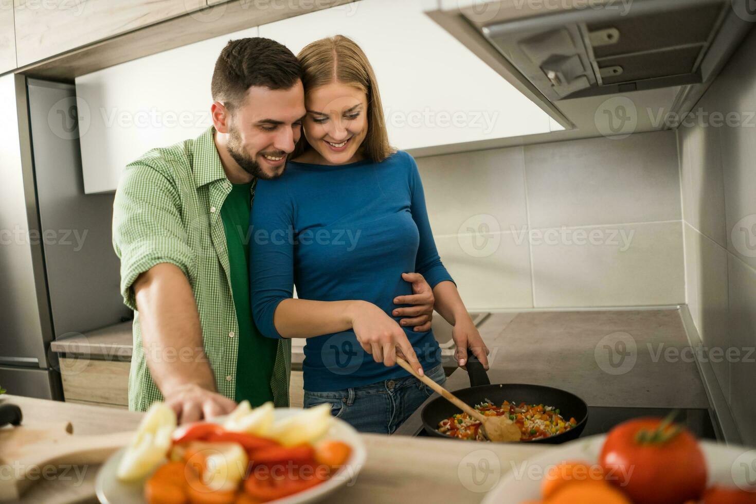 uma jovem casal cozinhando juntos foto