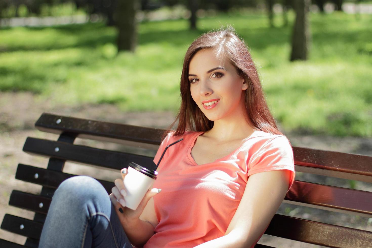 mulher relaxando em um banco do parque foto
