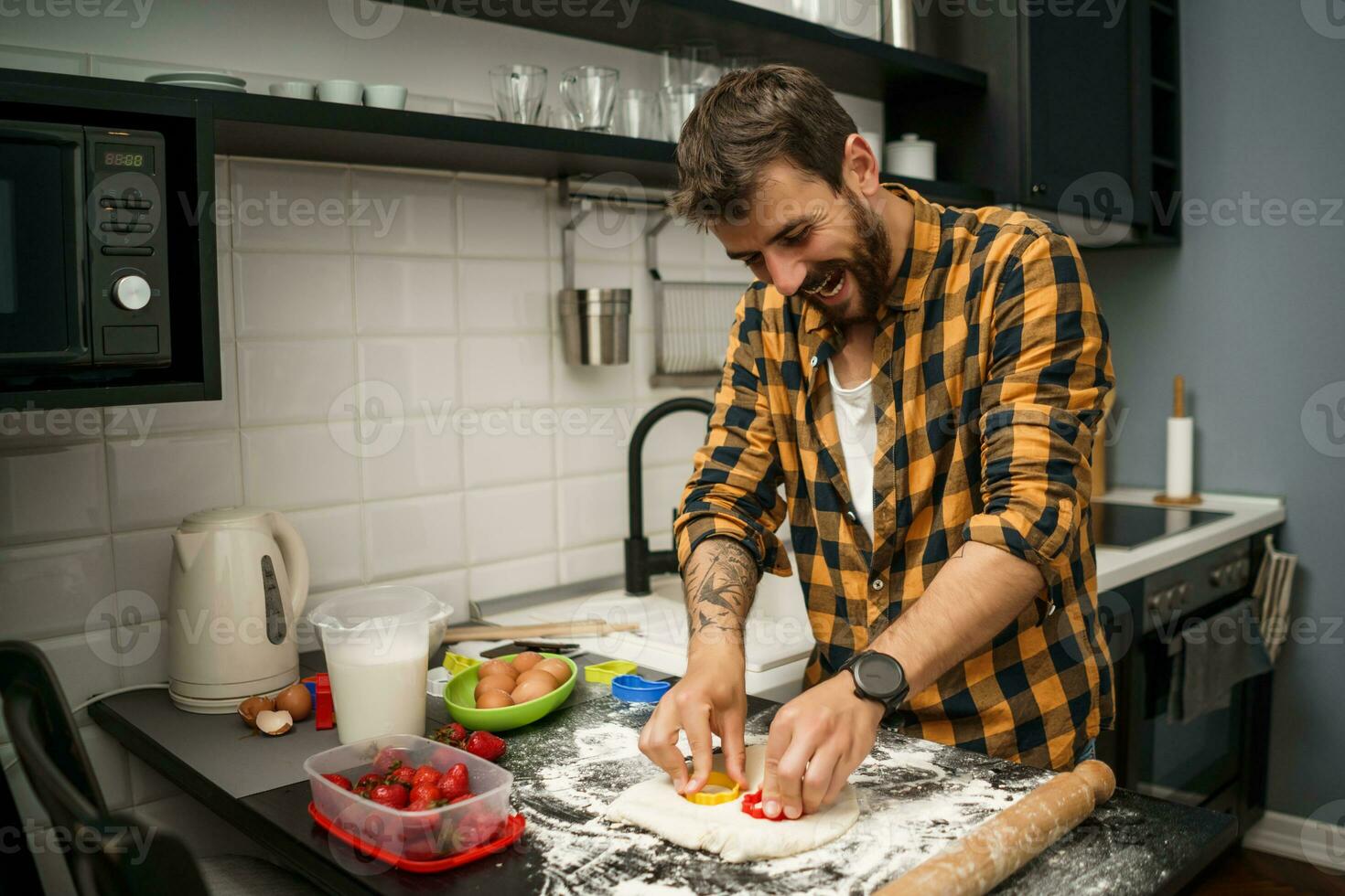 uma homem cozimento biscoitos dentro a cozinha foto