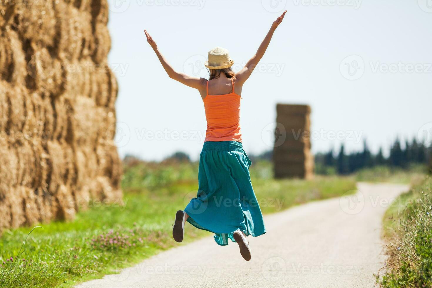 uma mulher em a estrada pulando foto