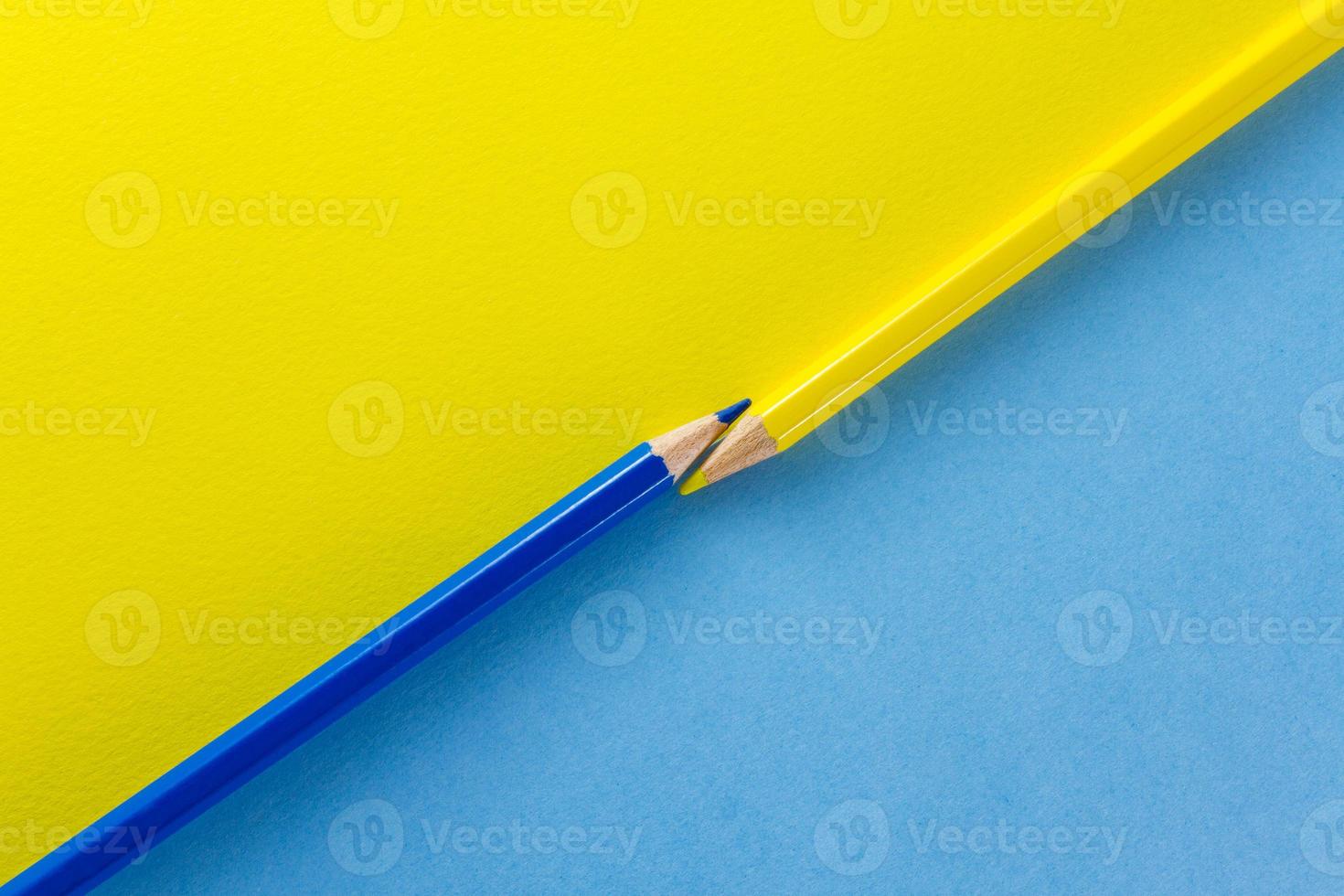 lápis de cor em papéis de cor amarela e azul dispostos diagonalmente foto