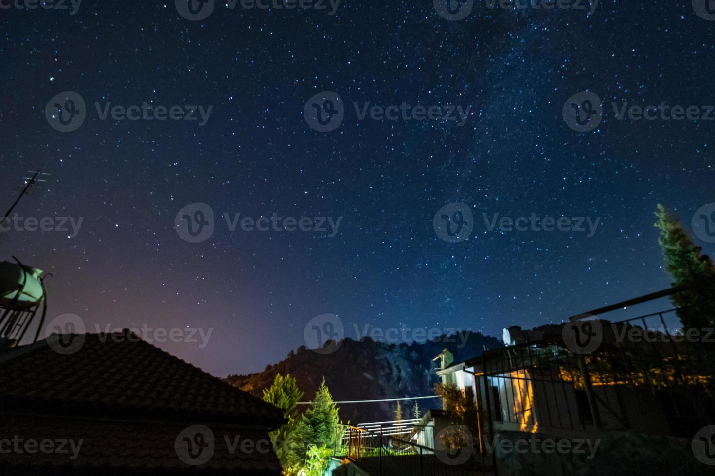 estrelas e via láctea sobre a floresta e uma casa nas montanhas troodos foto