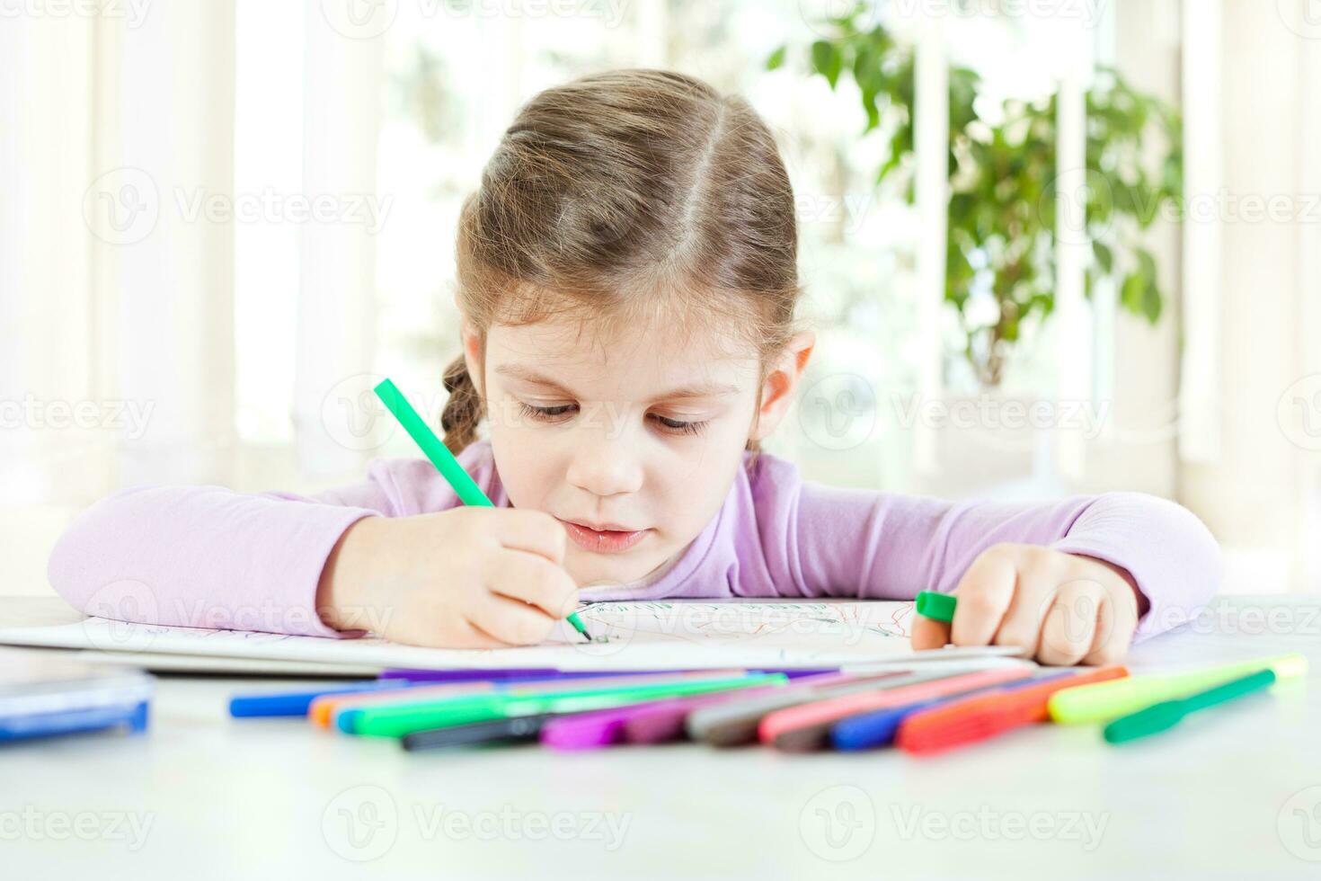 pequeno menina coloração uma livro às casa foto