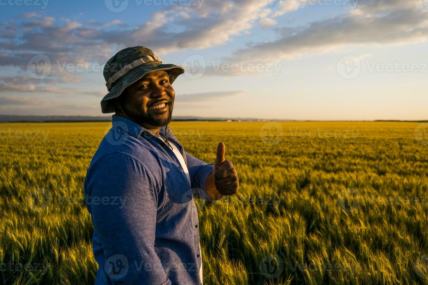 afro agricultor em pé dentro uma trigo campo foto