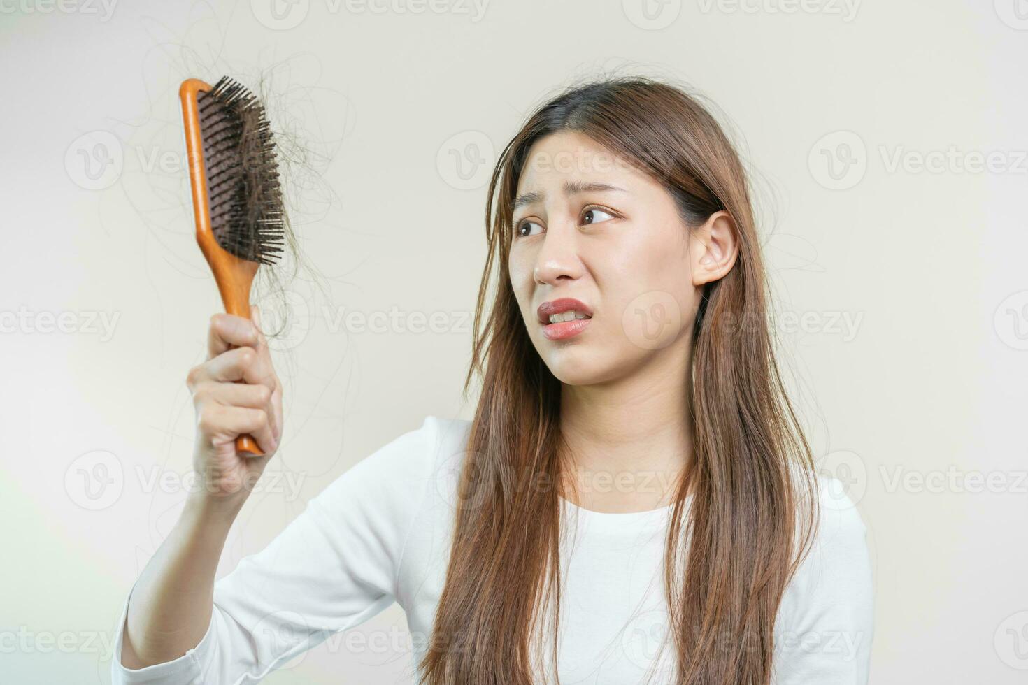 sério, preocupado ásia jovem mulher, menina segurando escovar, mostrar dela pentear, escova de cabelo com grandes perda cabelo problema depois de escovar, cabelo outono Fora em dela mão dentro vivo sala. saúde Cuidado, beleza tratamento. foto