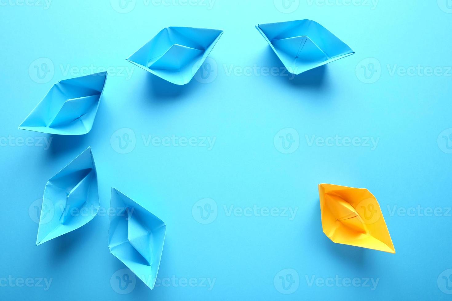 conceito minimalista com barcos de origami em fundo azul foto