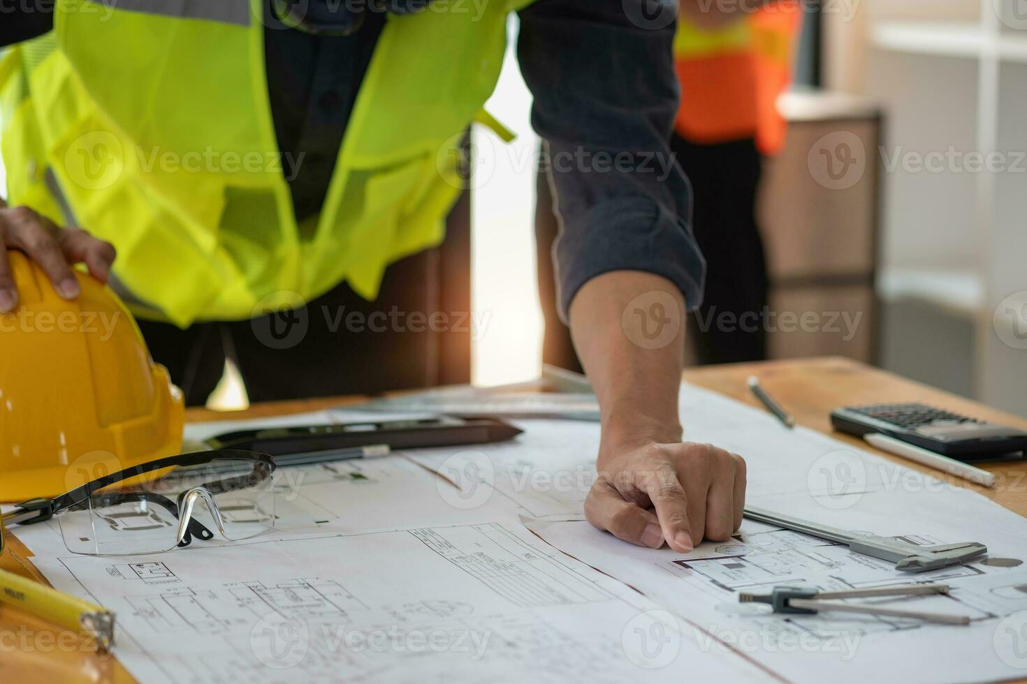 ásia engenheiros chuva de ideias e a medida para documento custo estimativas e escrever chão planos para arquitetônico e Engenharia desenhos para casas e edifícios. foto