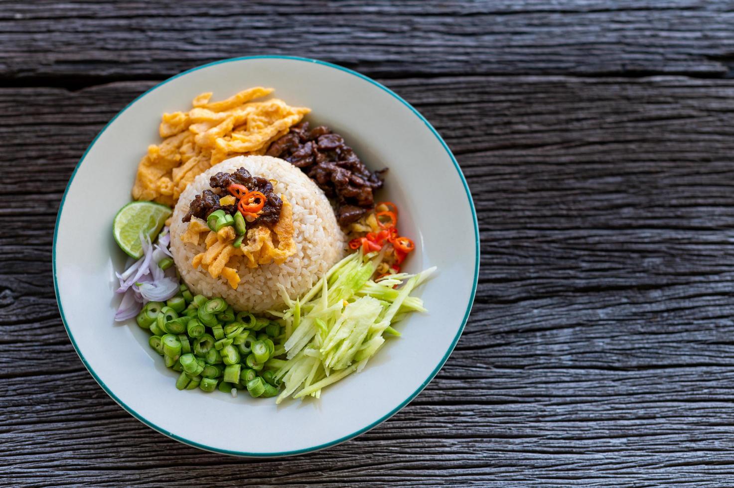 Pasta de camarão tailandês arroz frito com porco doce na mesa de madeira, vista de cima foto