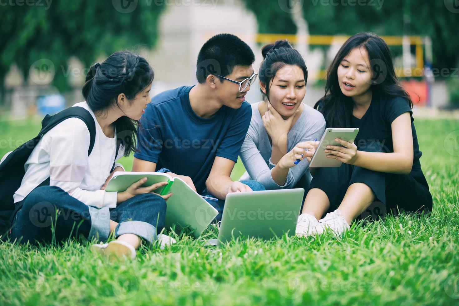 grupo de estudantes asiáticos no gramado do campus foto