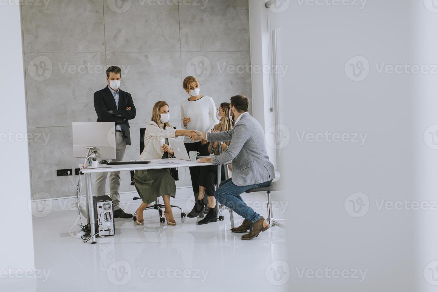 grupo em um escritório moderno usando máscaras foto