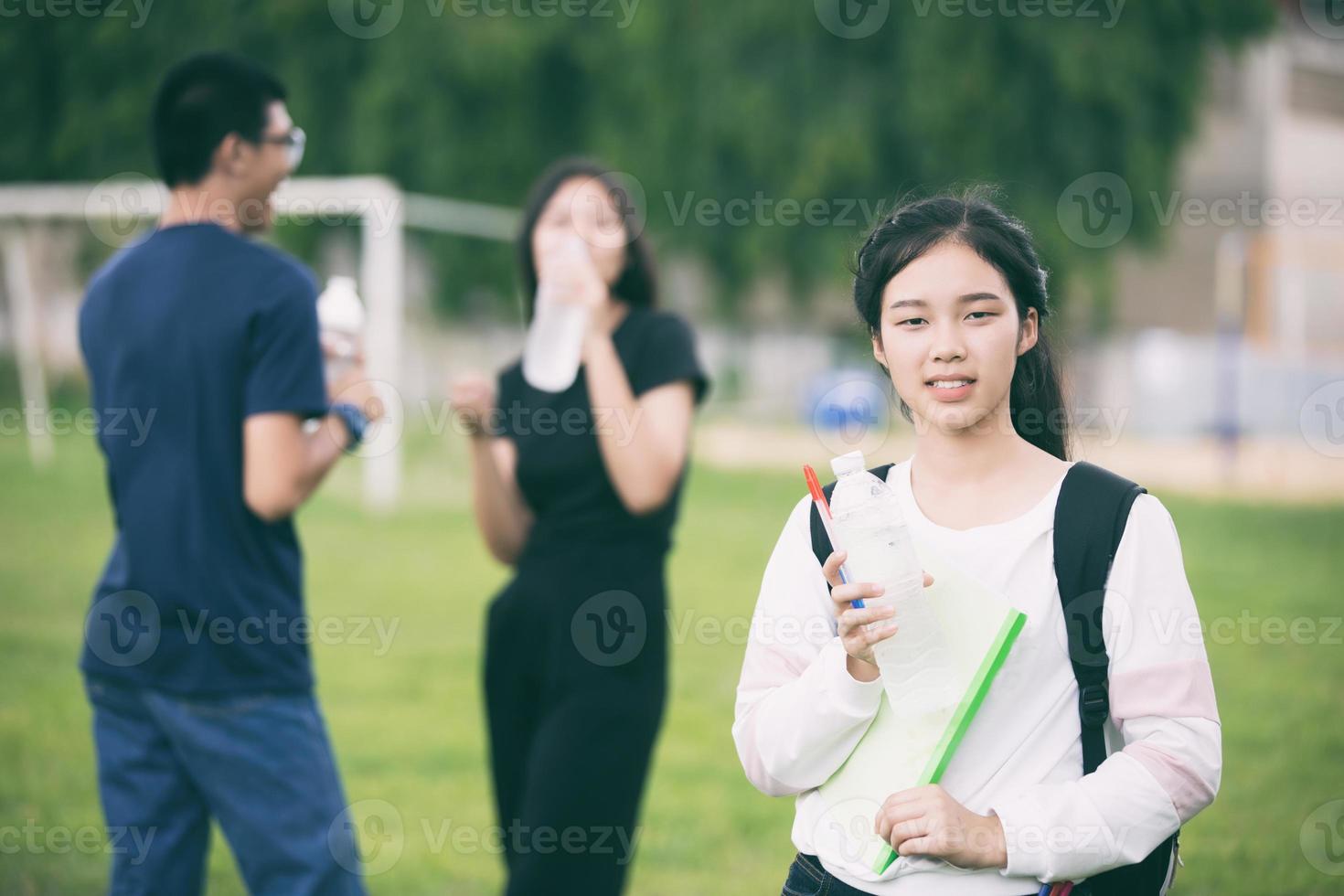 estudante asiática segurando água no campus foto