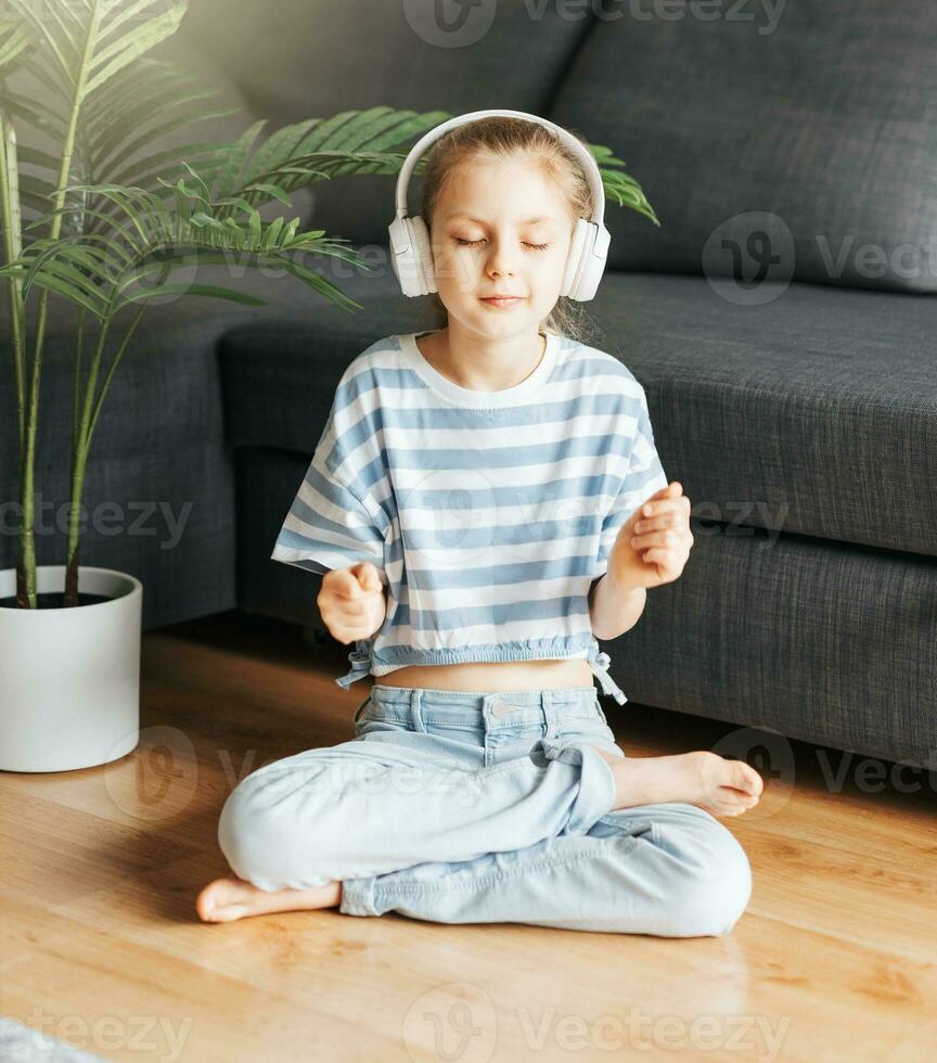 fofa pequeno menina ouvindo para música dentro fones de ouvido foto