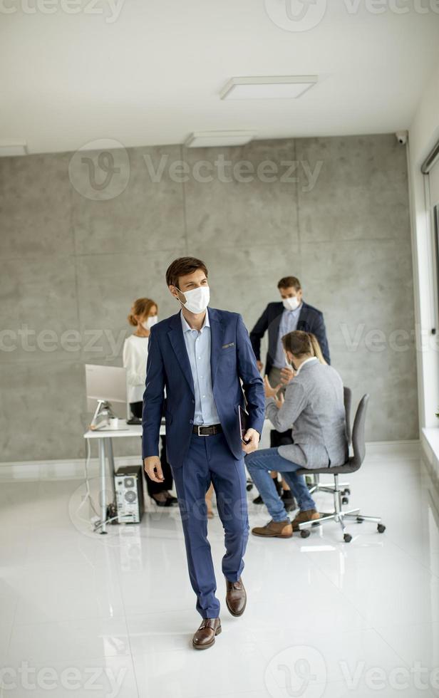 homem saindo da reunião com máscara foto