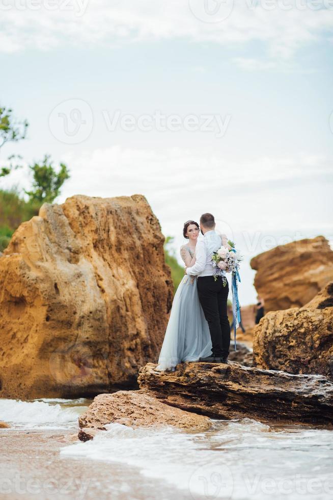 o mesmo casal com uma noiva em um vestido azul anda foto