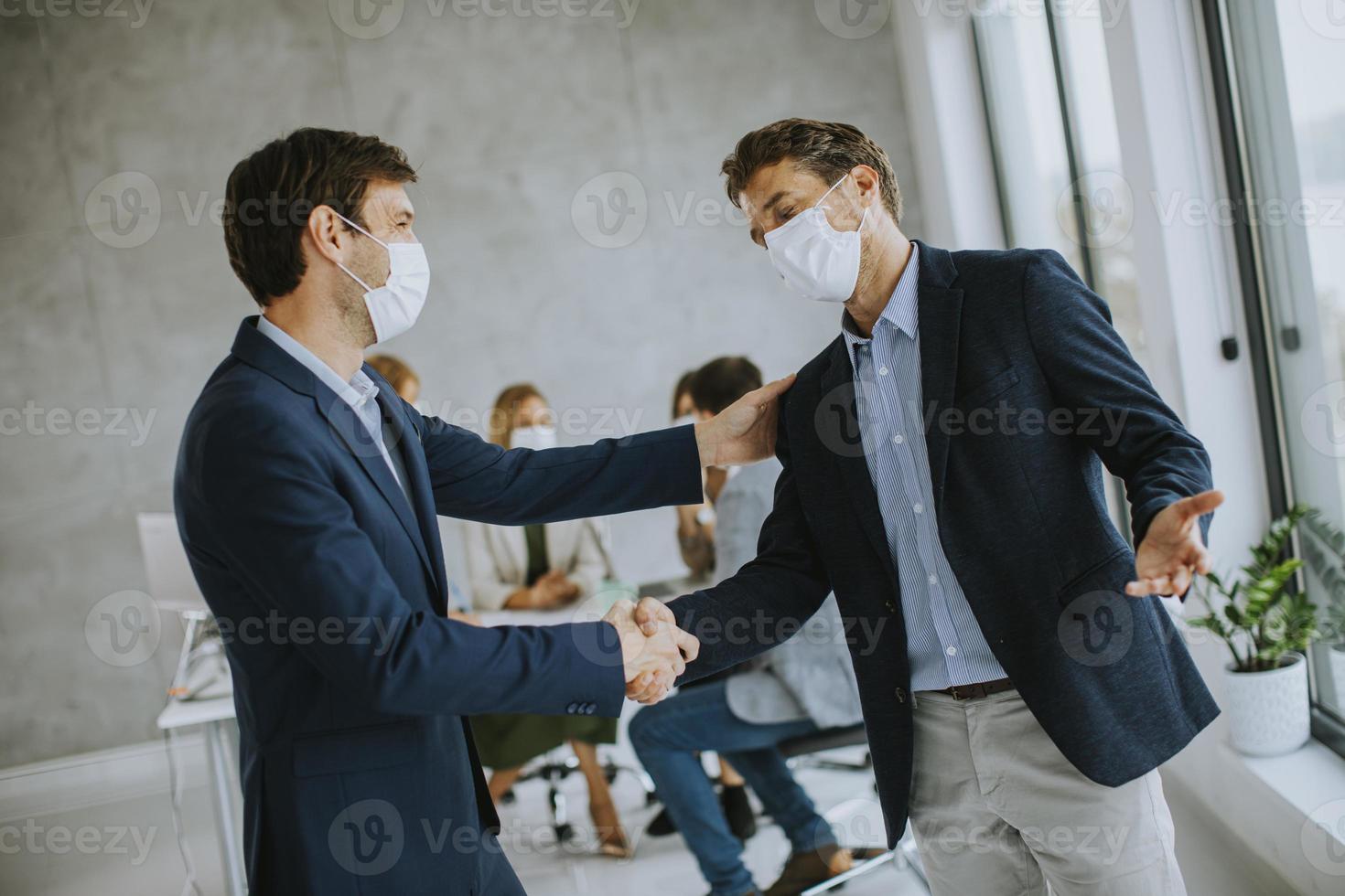 dois homens mascarados fazendo um acordo comercial foto